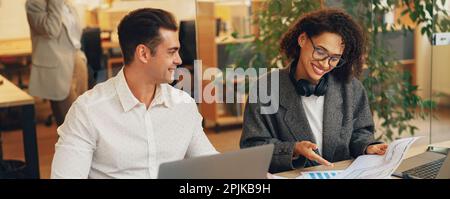Two colleagues working together with documents while sitting on office desk. Teamwork concept Stock Photo