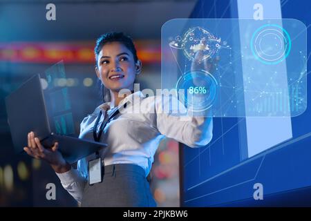 Businesswoman using laptop touching on virtual screen Stock Photo