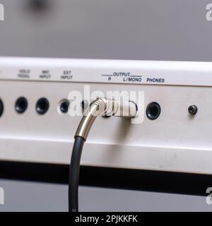 Audio jacks are plugged into a guitar synthesizer or processor Stock Photo