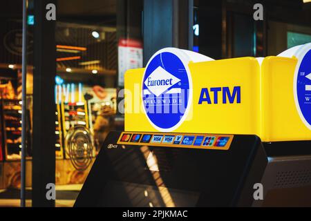 Euronet Worldwide ATM. Blue and yellow Sign on a modern Cashpoint. Global network of thousands of ATMs. Vilnius, Lithuania - March 8, 2023. Stock Photo
