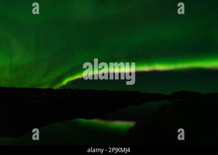 Aurora borealis pink and green light beams over the lake Stock Photo