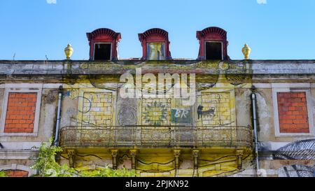 Lisbon, Portugal - January 4, 2023: Old building with faded yellow painting  in the center Stock Photo