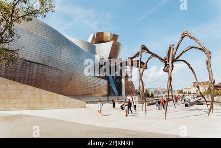 Bilbao, Spain - September, 2022: Guggenheim Museum next to the spider sculpture Maman in Bilbao. Guggenheim Museum Bilbao is museum of modern and cont Stock Photo