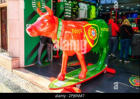 Lisbon, Portugal - January 4, 2023: Vibrant Cow Statue Painted in Brazilian colors in front of a football store. Stock Photo