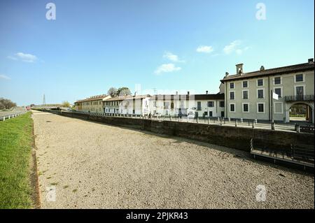 The dry riverbed of  Naviglio Grande canal during bank restoration works in Abbiategrasso, Milan, Italy on March 23, 2023 Stock Photo