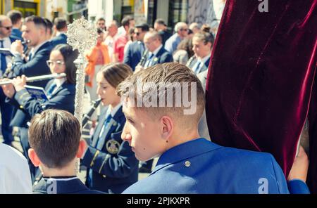 Seville, Spain; April 2, 2023: Young boy of Hiniesta Brotherhood during the processions of Holy Week. Palm Sunday. Stock Photo