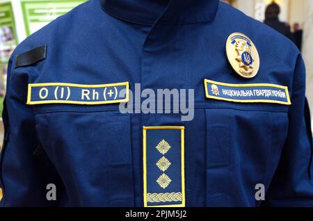Upper part of Ukrainian police uniform, cold-climate clothing: coat, chevron, police badge, patch with blood type. October 7, 2018. Kiev, Ukraine Stock Photo