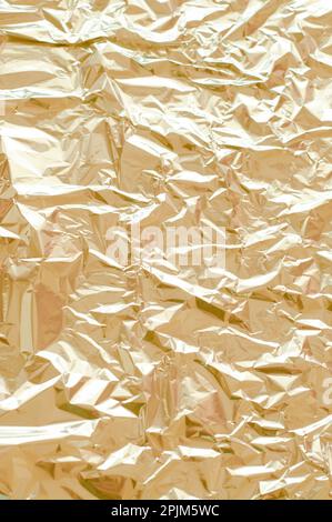 Metallic foil texture. Gold, golden background. Metal glittering, crushed, glister surface, backdrop. Crumpled texture. Reflective surface. Folded, ru Stock Photo
