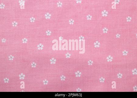 Pink cotton fabric with small white flowers texture. Floral textile background Stock Photo
