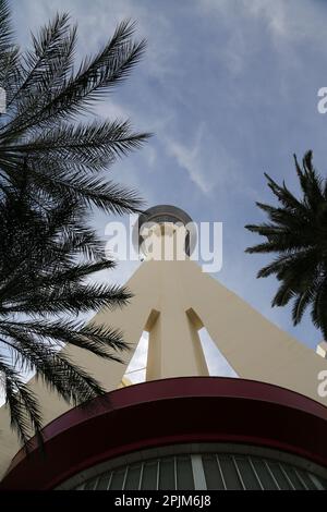 View from below on Stratosphere tower in Las Vegas against blue sky, with some palm trees Stock Photo