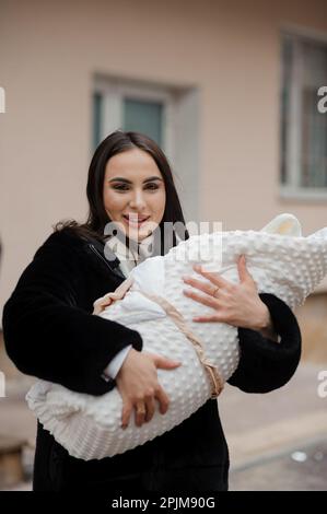 Woman holding a baby wrapped in a blanket Stock Photo