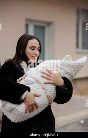 Woman holding a baby wrapped in a blanket Stock Photo