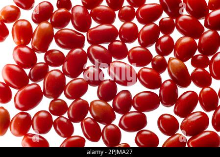 Scattered red cherry tomatoes as background, datterino tomato, top view isolated on white with clipping path included Stock Photo