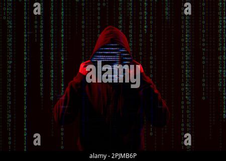 Silhouette of anonymous hacker and digital binary code on dark background. Cyber attack concept Stock Photo