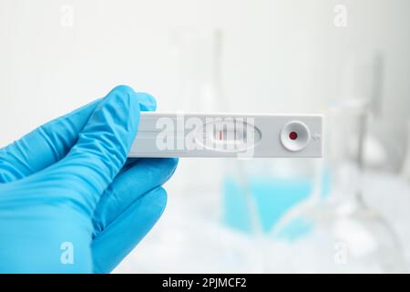 Doctor holding disposable express test for hepatitis indoors, closeup Stock Photo