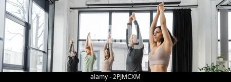 Interracial people practicing Crescent Lunge pose in yoga studio, banner,stock image Stock Photo