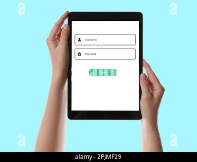 Woman holding tablet with authorization interface on screen against cyan background, closeup Stock Photo