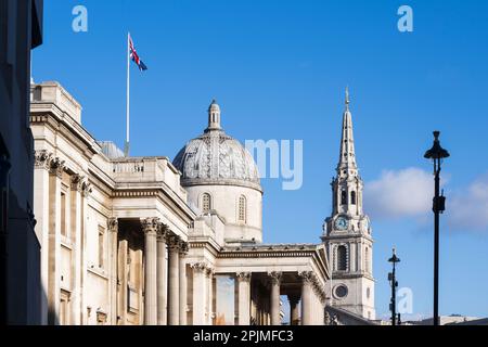 A Union Jack flag flying over The National Gallery with the spire of St. Martin-in-the-Fields in the background. The National Gallery, Trafalgar Squar Stock Photo
