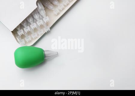 Package with single dose ampoules of sterile isotonic sea water solution and nasal aspirator on white background, top view. Space for text Stock Photo