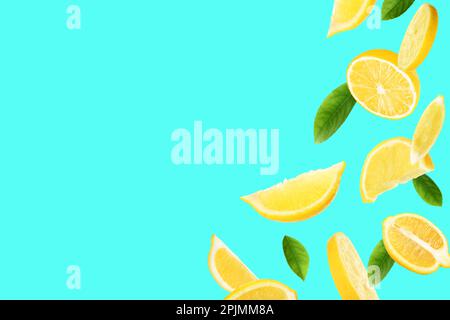 Fresh ripe lemons and green leaves on turquoise background. Space for text Stock Photo
