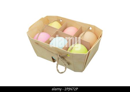 Easter eggs in wooden box isolated on white background. Rainbow colored Easter eggs isolated. Group of easter eggs in a row. Stock Photo