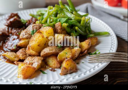 Pan fried potatoes on a dinner plate Stock Photo