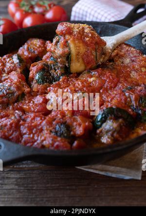 Zucchini roulades with minced meat filling and tomato sauce. Italian involtinis. Stock Photo