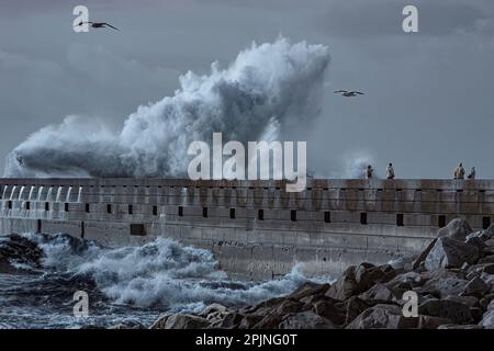 Porto, Portugal - December 31, 2015: People watching the storm in the Douro river mouth pier, north of Portugal. Used infrared filter. Stock Photo