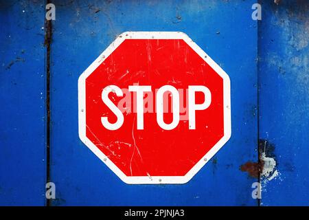 Stop sign on blue garage door with vignette Stock Photo