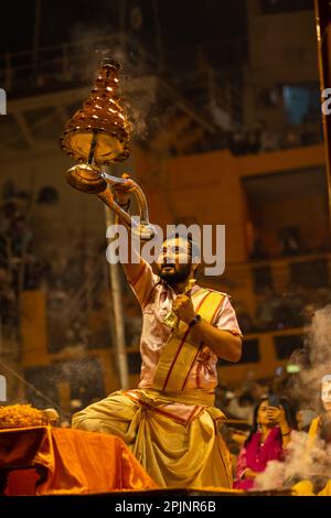 Ganga aarti, Portrait of an young priest performing river ganges evening aarti at Dashashwamedh Ghat in traditional dress with sanatan hindu rituals. Stock Photo