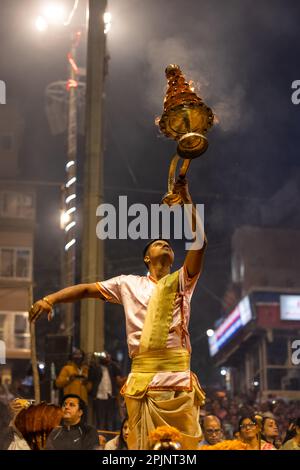 Ganga aarti, Portrait of an young priest performing river ganges evening aarti at Dashashwamedh Ghat in traditional dress with sanatan hindu rituals. Stock Photo