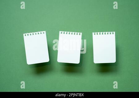Torn white paper note sheet isolated on green desk. copy space Stock Photo