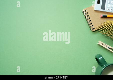 School office supplies. notebook, calculator, pencil, cup of milk on green desk background. flat lay, top view, copy space Stock Photo