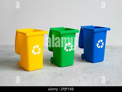 Blue, yellow and green open tank for separate garbage collection on a light background, waste recycling and conservation of the environment concept Stock Photo