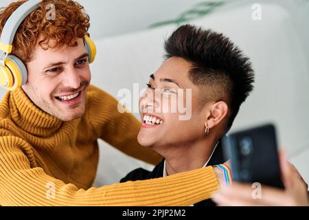 Gay couple taking a selfie while smiling at home Stock Photo