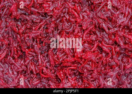 Background and texture of raw fresh juicy grated red beetroot vegetable, close up, top view Stock Photo