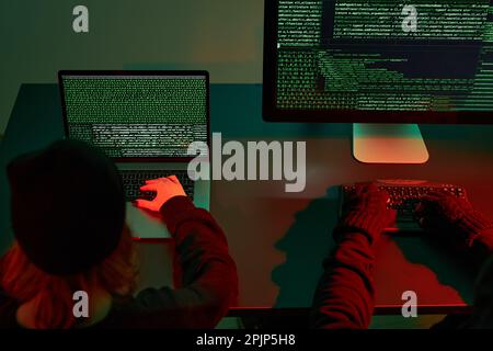 Anonymous people using computer and programming to break code. Cyber security threat. Internet and network security. Access to private information. An Stock Photo
