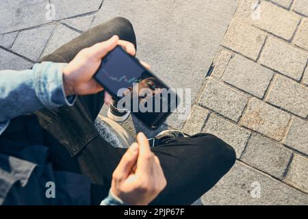 Person investing trading on stock cryptocurrency market using investing application on smartphone. Stock market investment in hand. Trader holding mob Stock Photo