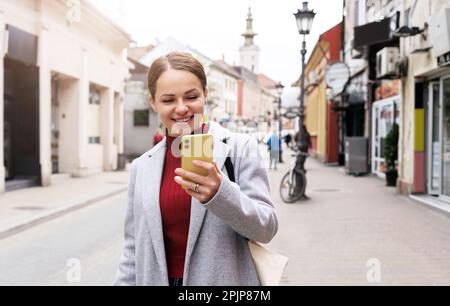 Woman traveling around town using digital map mobile app navigation on her smartphone. Stock Photo