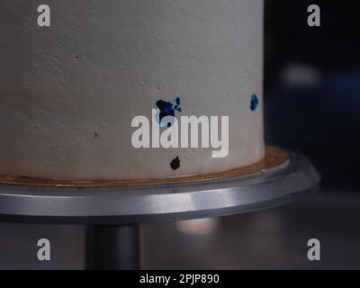 pastry chef working on a frosted cup cake with lgbt rainbow colours for wedding union party celebration. Birthday cupcake. Rainbow paper cup liners. H Stock Photo