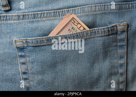 Fifty dollar bill in the pocket of the jeans, close up Stock Photo