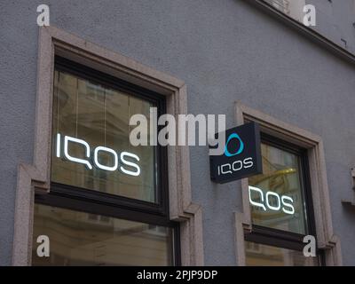 Linz, Austria - August 6, 2022: Facades IQOS store in city. IQOS advertisement. Heating tobacco system iqos tobacco product technologies beloning to P Stock Photo