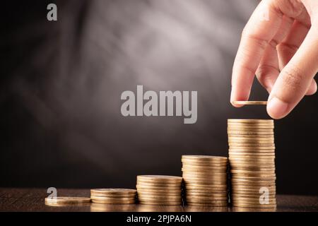Saving money concept hand putting coin on stack Stock Photo