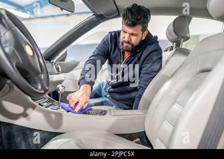 manual cleaning and polishing of luxury car interiors with a microfiber Stock Photo