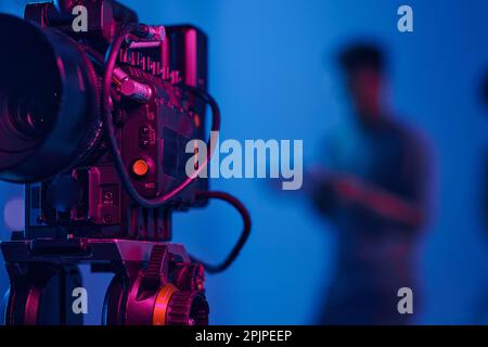Close-up of professional camera setting for shooting with operator working in background Stock Photo