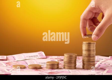 Money making or profitable business concept, hand putting coin on stack Stock Photo
