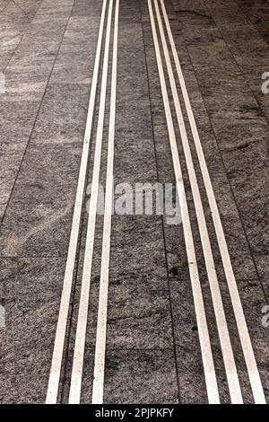 White lines on grey stone floor tiles for use as a background texture Stock Photo
