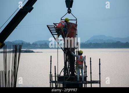 Construction workers busy build pillars of a bridge in the banks of ...