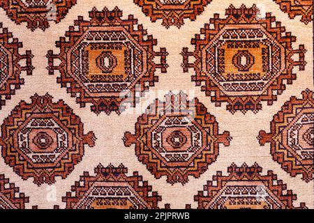 Colorful handmade silk carpet with pattern in red tones, traditional uzbekistan style. Close up. Stock Photo