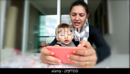 Mother and toddler child looking at cellphone screen Stock Photo